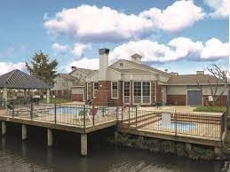 A house with a pool and a deck over water.