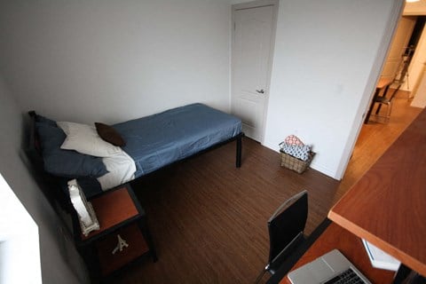 a small bedroom with a bed and a desk with a computer