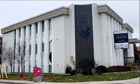 the building is shown from the side of the street