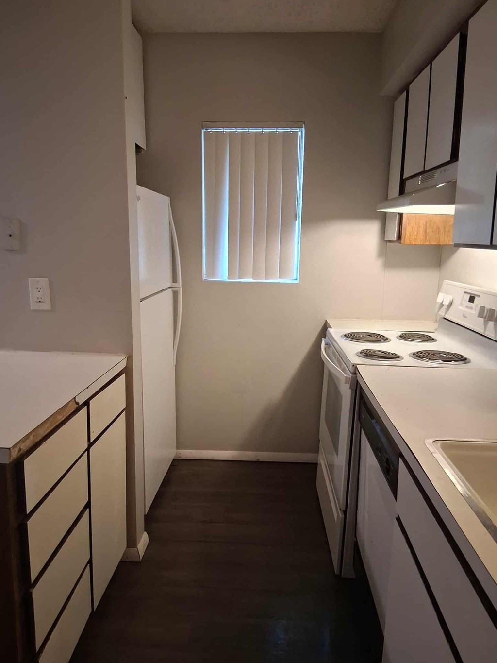 A small kitchen with white appliances and wooden cabinets.