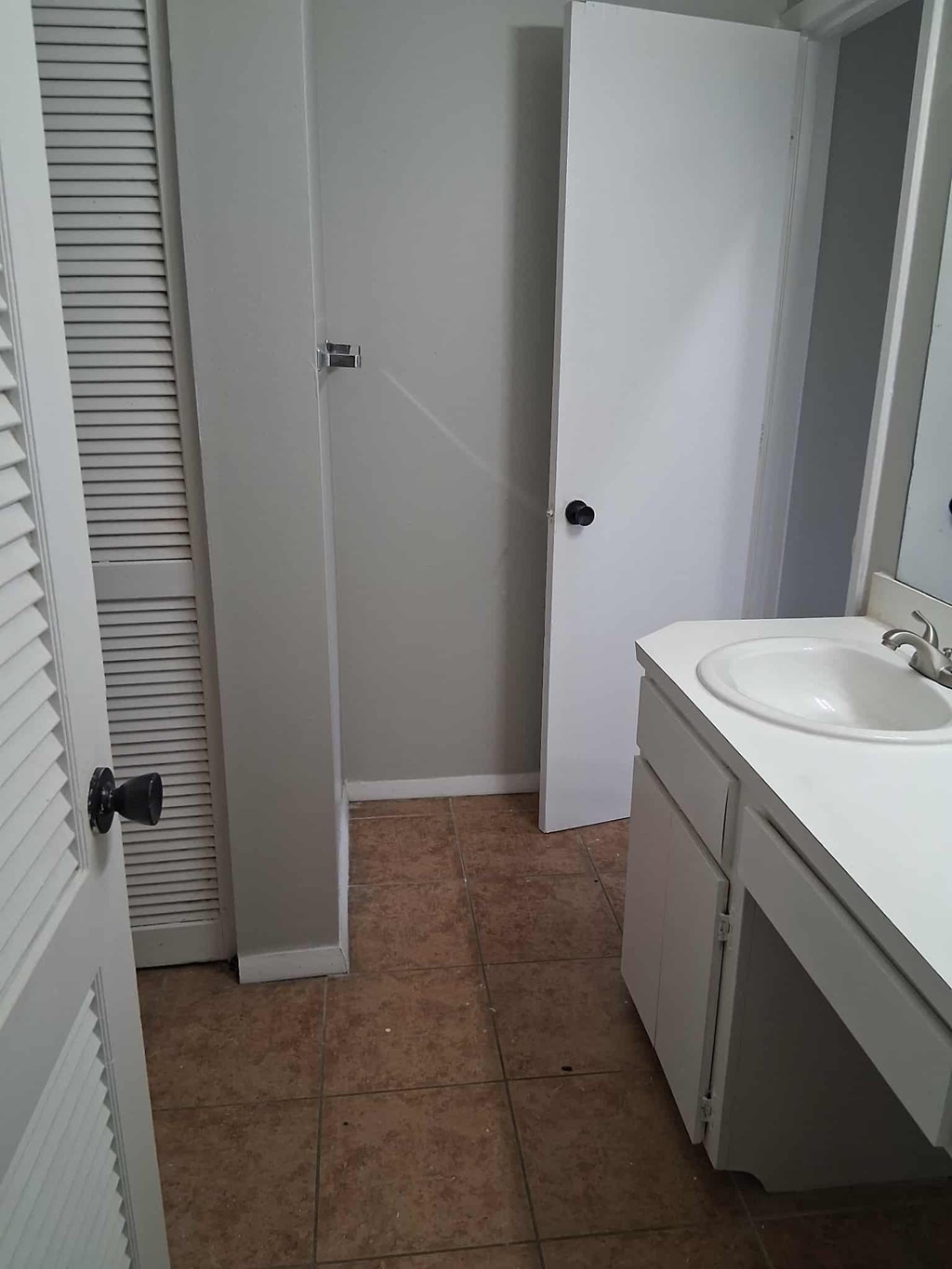 A bathroom with a sink, toilet, and a towel rack.