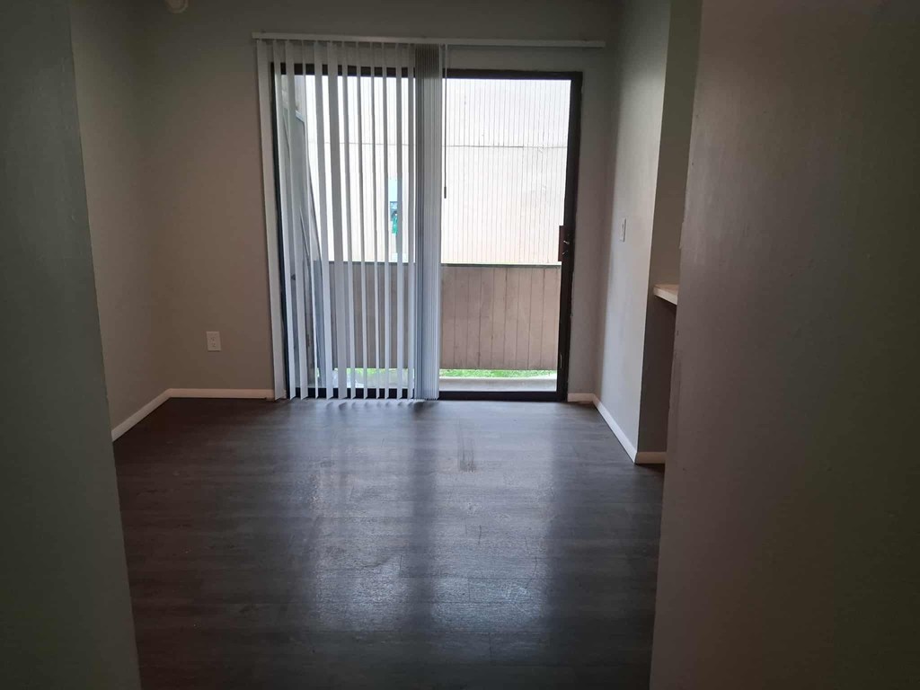 A room with a sliding door leading to a balcony.