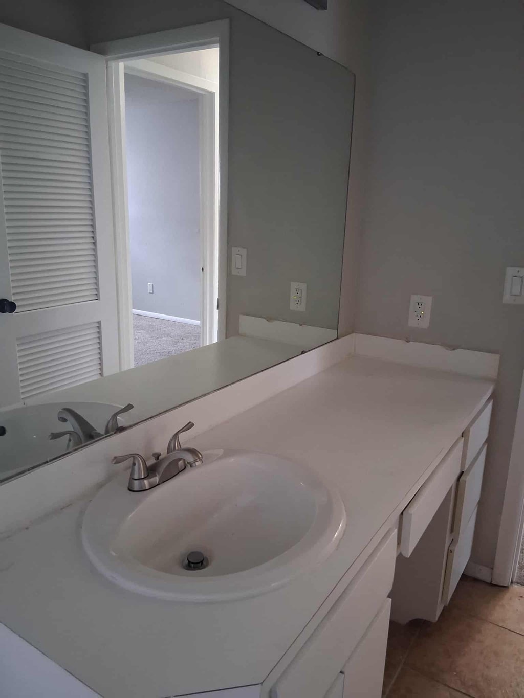 A white bathroom sink with a mirror above it.