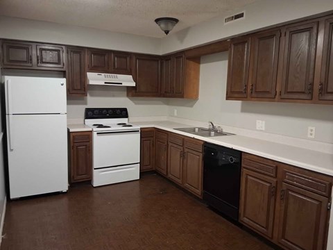 A kitchen with brown cabinets and white appliances.
