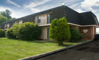 A house with a green bush in front of it.