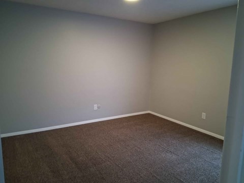 A room with a carpeted floor and a white wall.