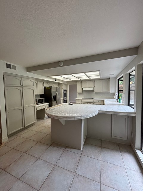 A kitchen with a table and chairs in the middle of the room.