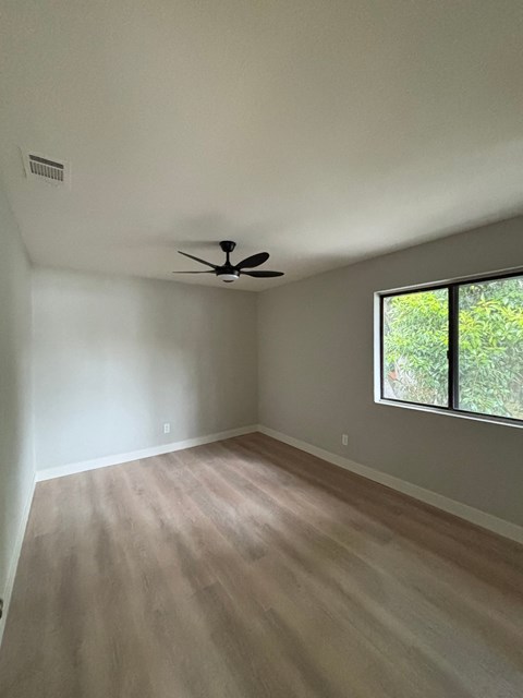 A room with a ceiling fan and a window.