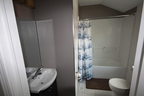 A bathroom with a white sink and a white toilet.