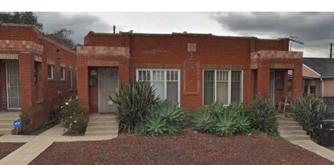 A red brick building with a white door and windows.