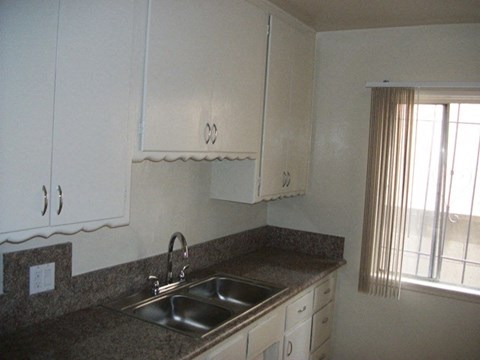 a kitchen with a sink and white cabinets
