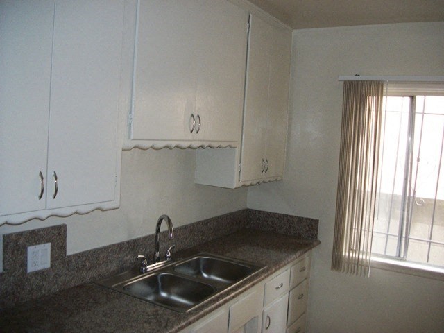 a kitchen with a sink and white cabinets