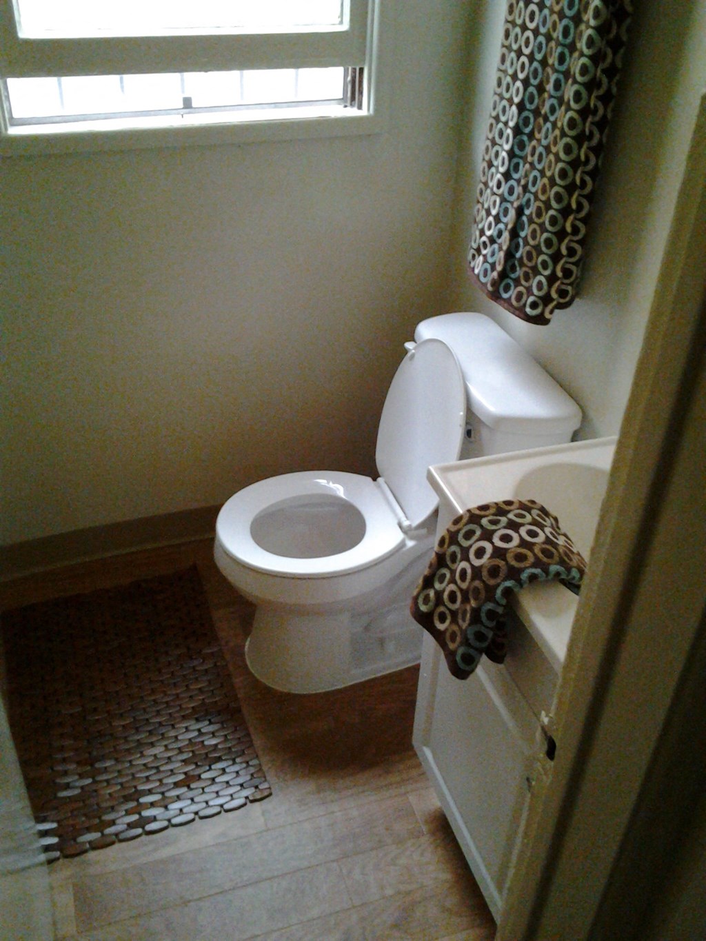 a bathroom with a toilet and a sink and a window