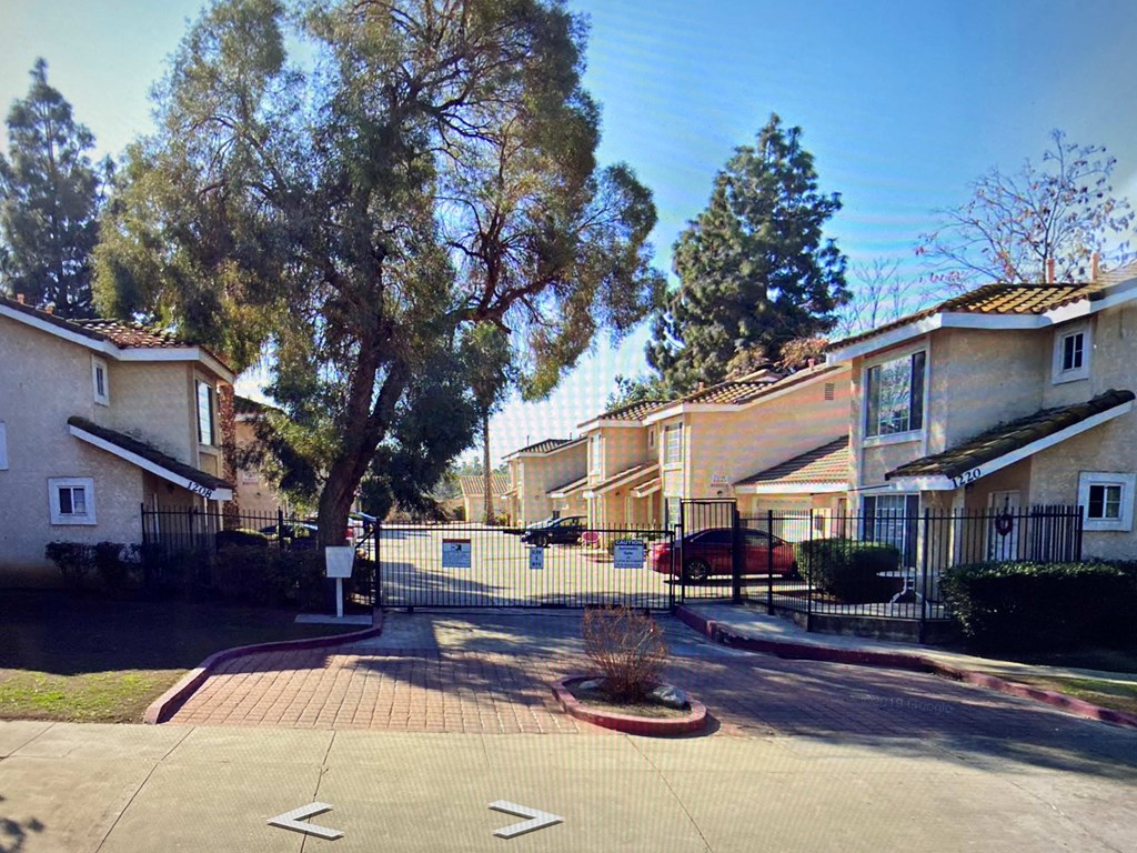 an apartment building with a parking lot and a fence