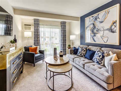 A living room with a grey couch, a coffee table, and a painting on the wall.