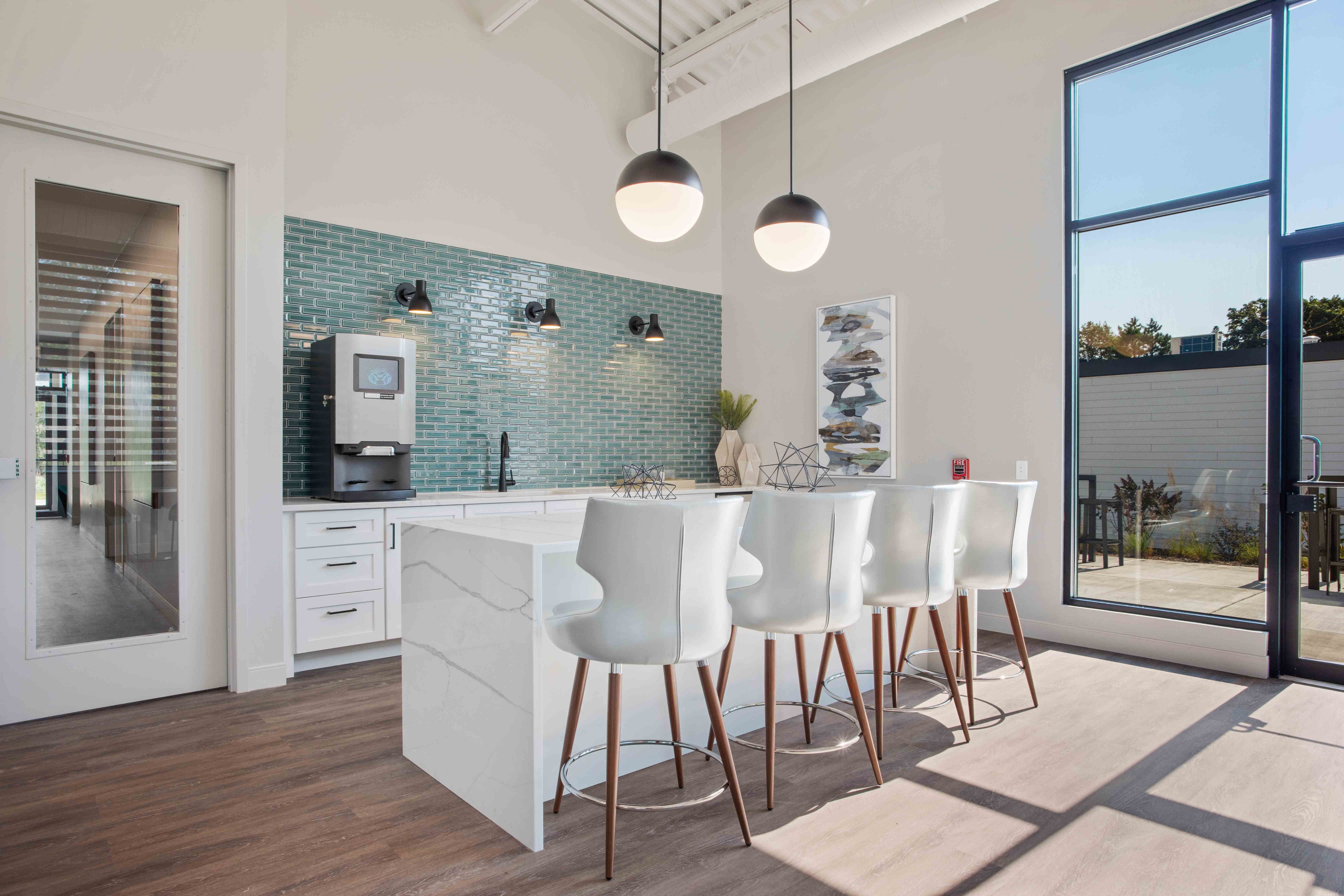 A kitchen with white chairs and a white counter.
