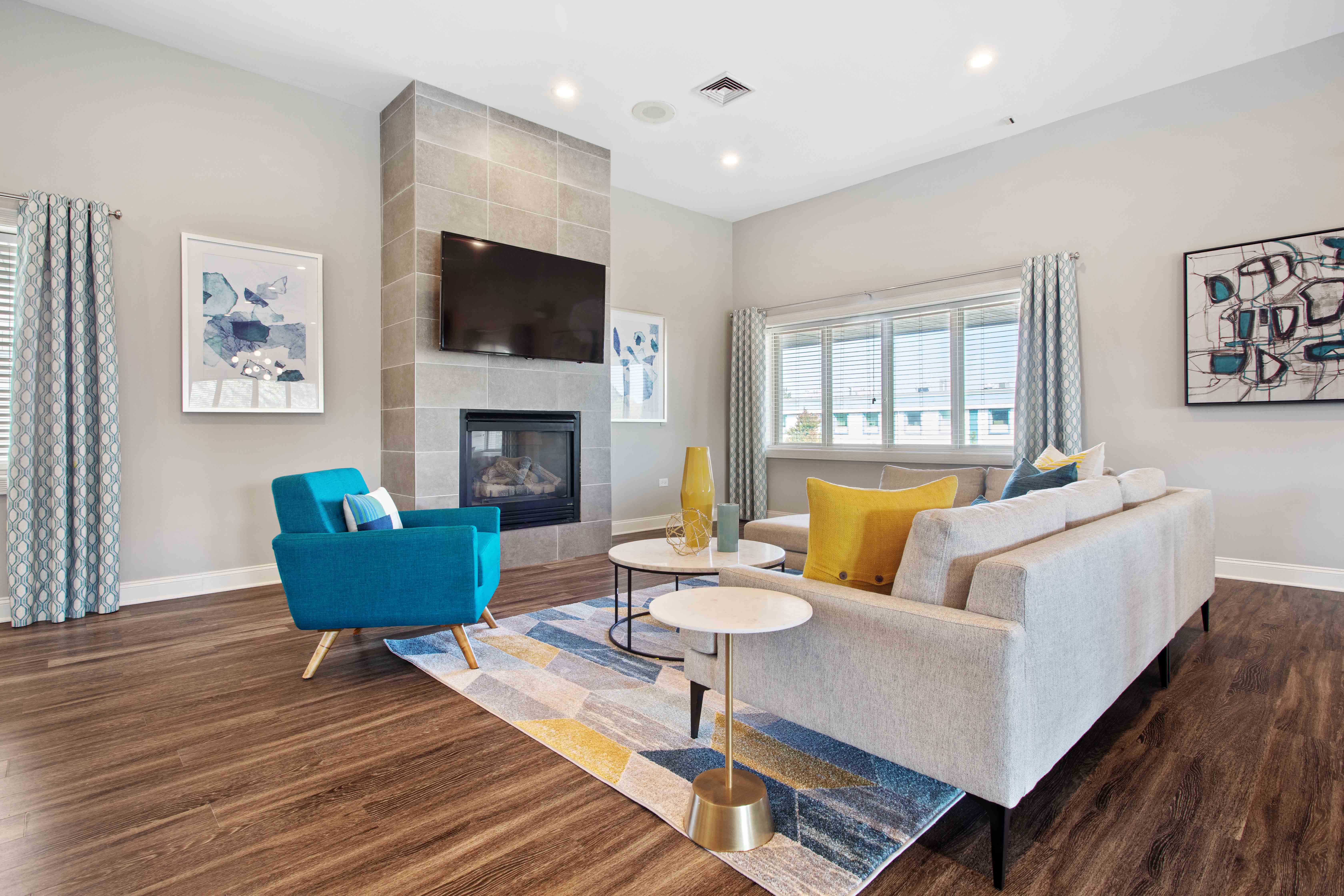 A living room with a blue chair and a grey couch.