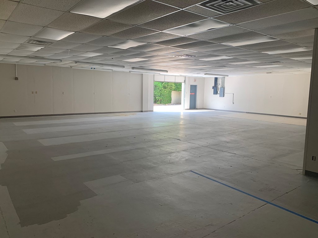an empty office space with white walls and a concrete floor