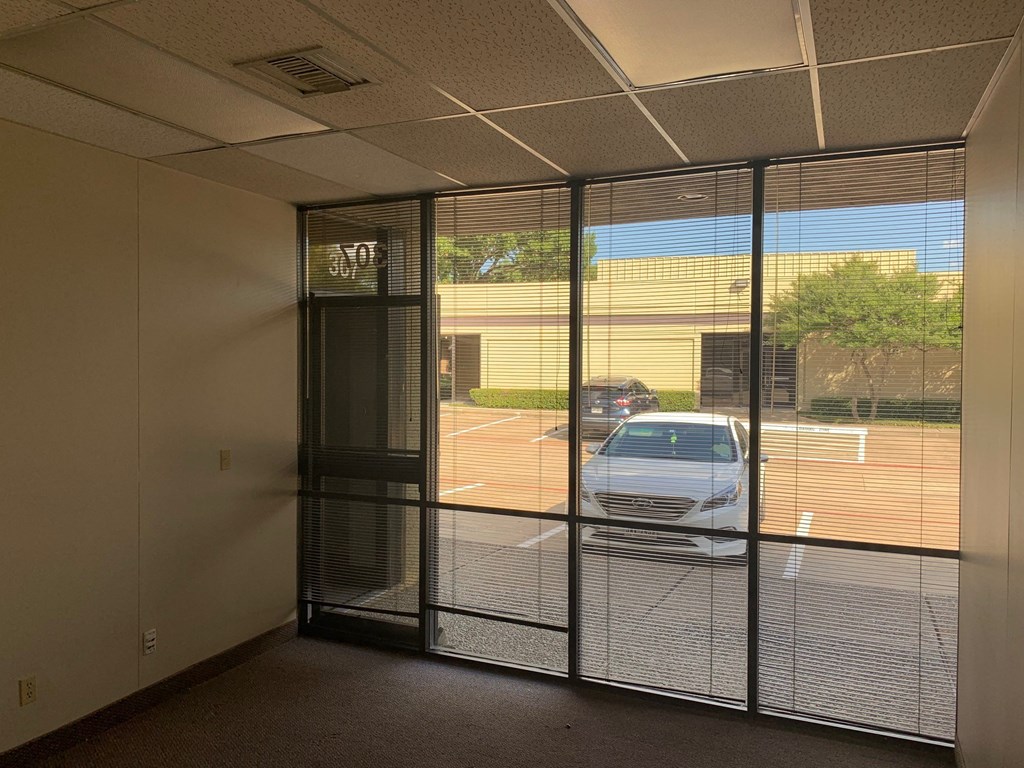 a car parked in a parking lot through a glass door