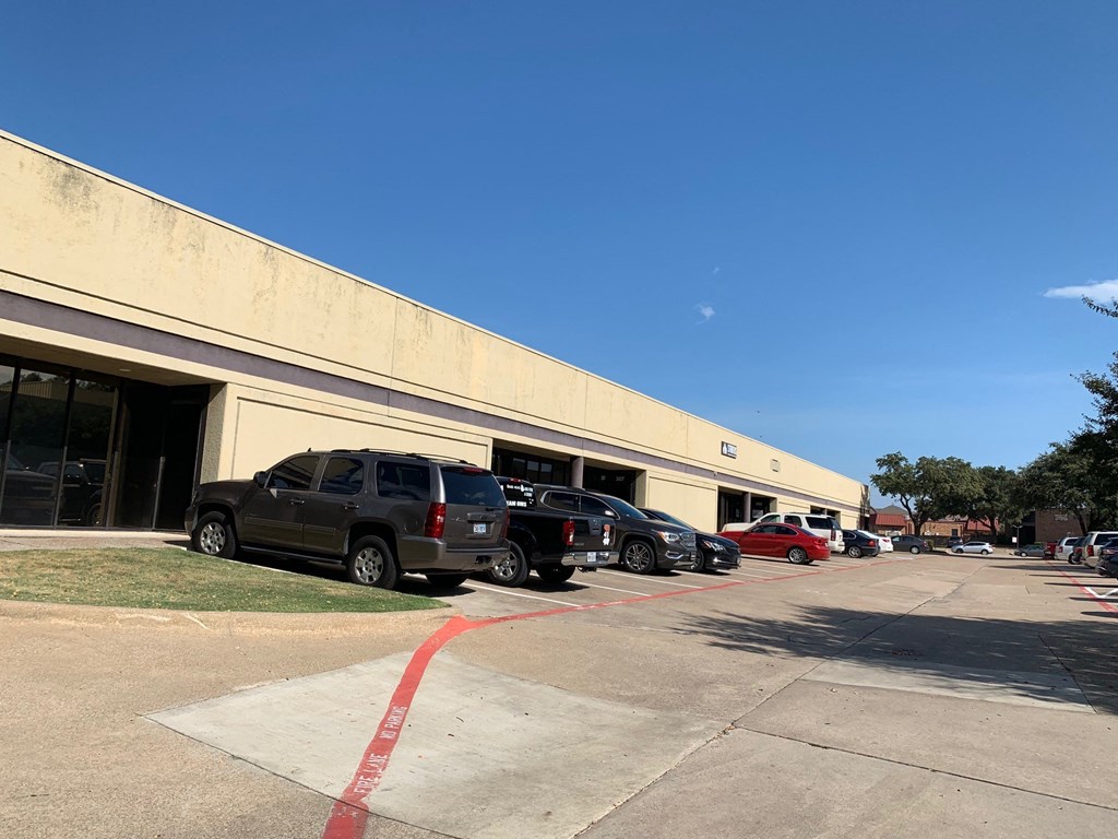 a parking lot full of cars in front of a building