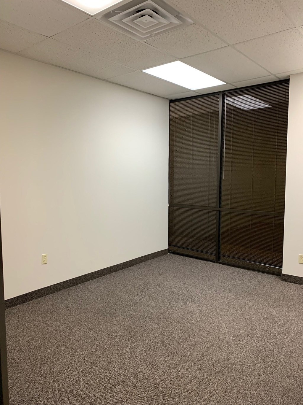 a room with white walls and a glass door