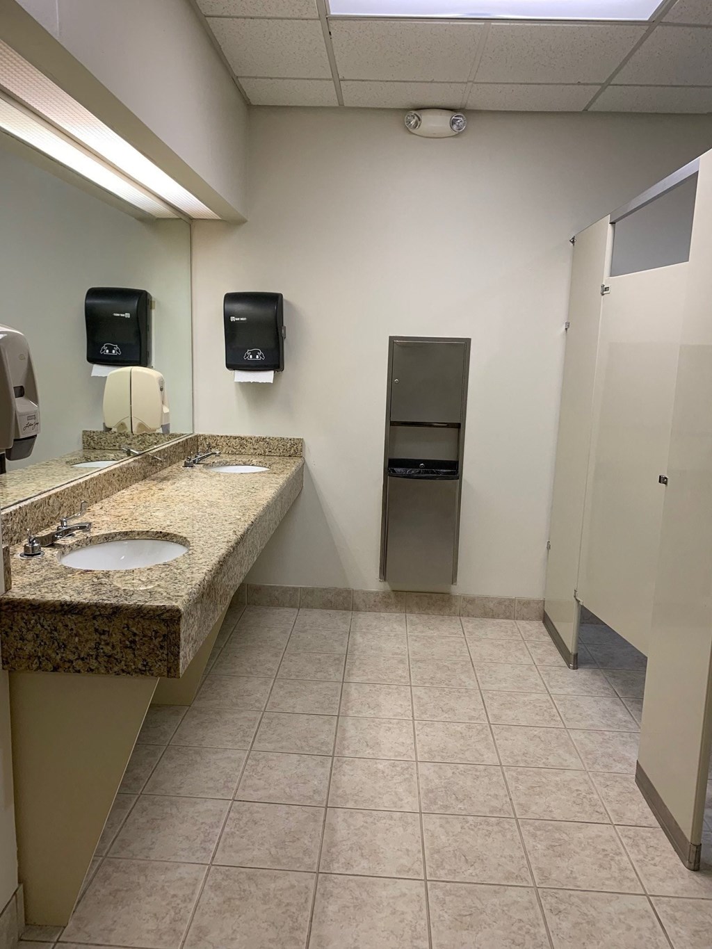 a public bathroom with two sinks and two toilets