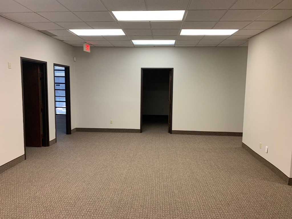 an empty room with a doorway into another room