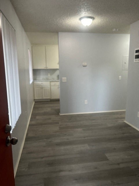 A room with a red door and a grey floor.