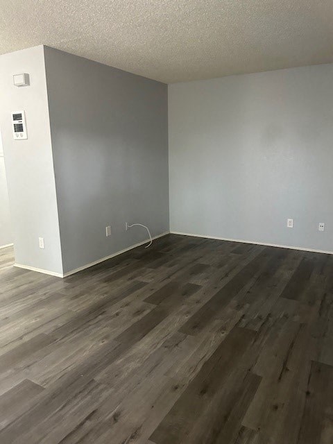 A room with wooden flooring and white walls.