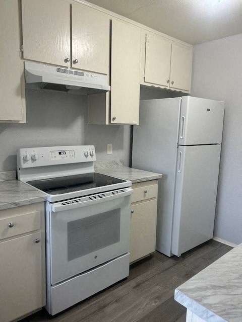 A white kitchen with a stove, oven, and refrigerator.