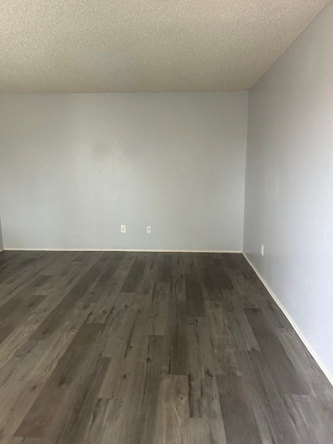 A room with wooden flooring and white walls.