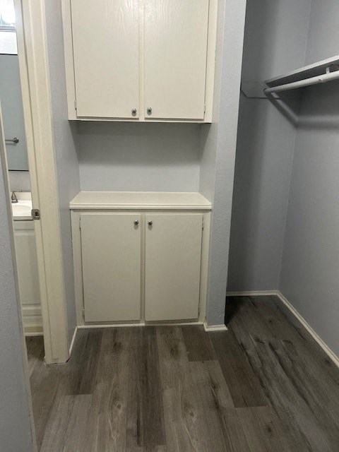 A white cupboard with two doors is in a room with grey walls.