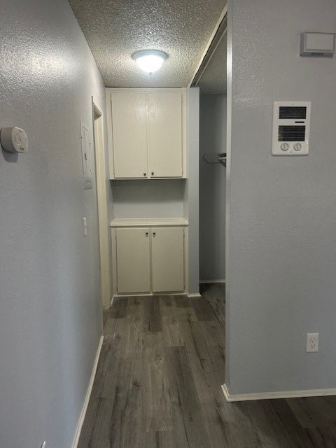 A long hallway with a wood floor and white walls.