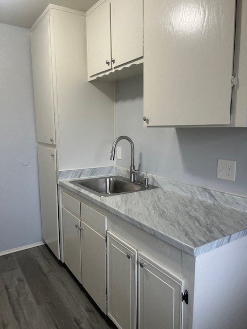 A kitchen with a marble countertop and white cabinets.