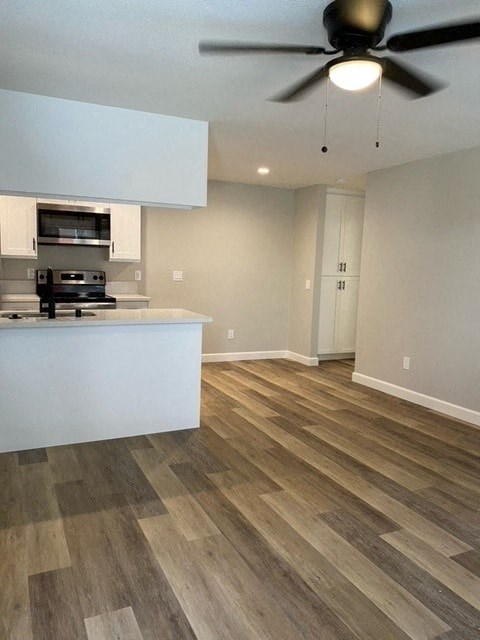 an empty kitchen and living room with a ceiling fan