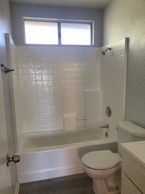 A white toilet sits next to a bathtub in a bathroom.