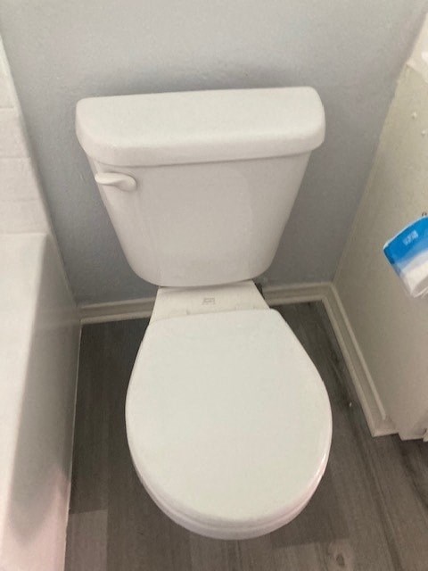 A white toilet in a small bathroom.