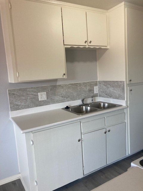A kitchen with white cabinets and a grey counter top.