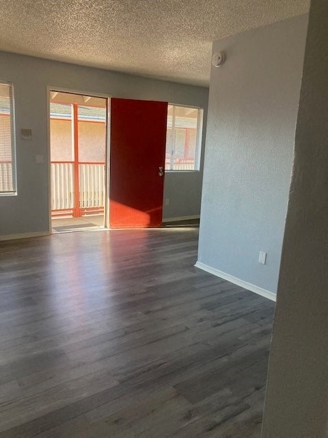 A room with a red door and wooden flooring.