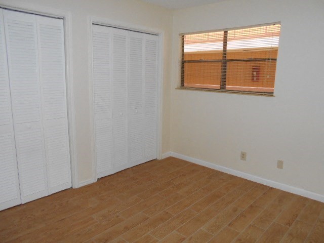 A room with white closet doors and a window with blinds.