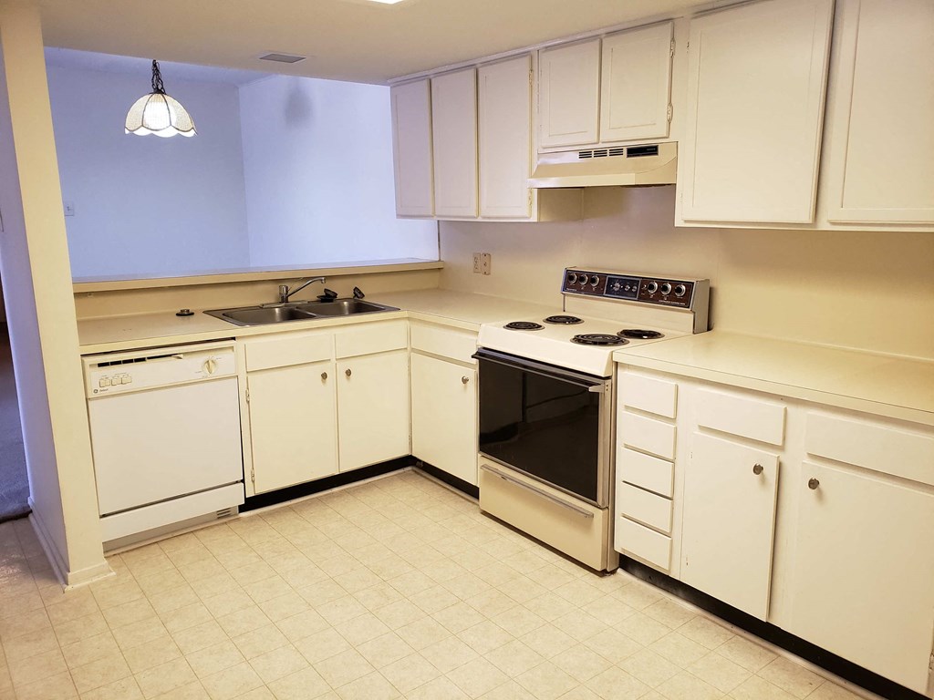a kitchen with white cabinets and a stove and a sink