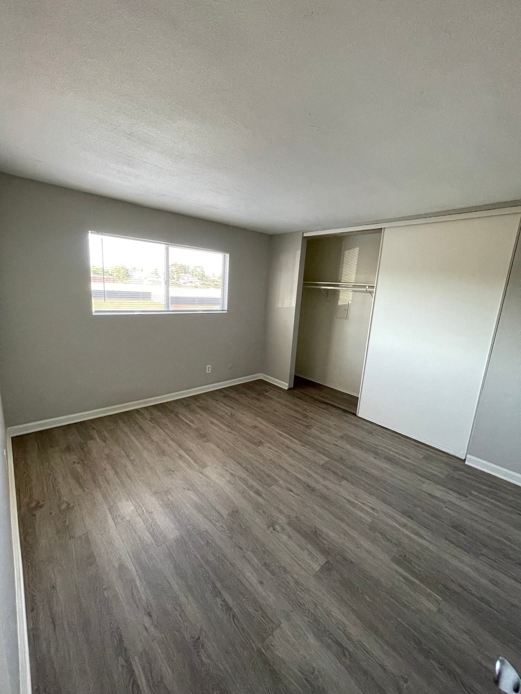 an empty bedroom with a closet and a window