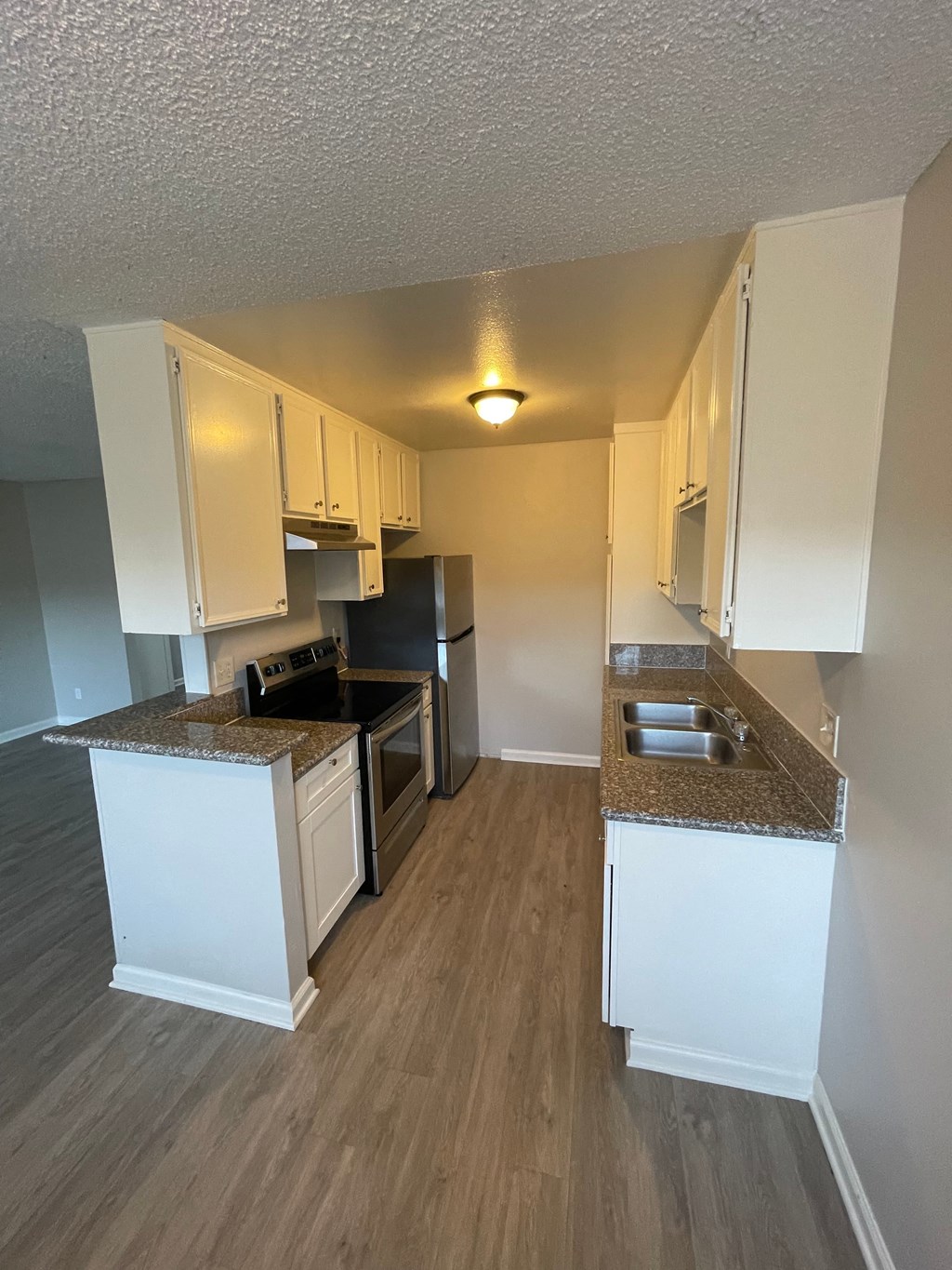 an open kitchen with white cabinets and stainless steel appliances
