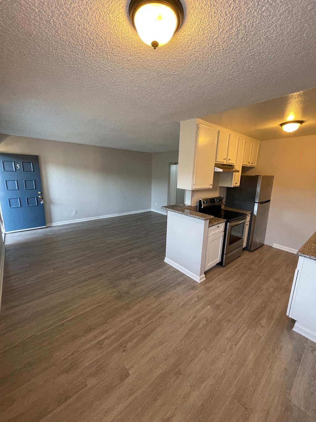 an open kitchen and living room with a wood floor