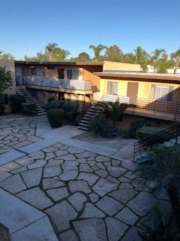 A courtyard with a stone floor and a building in the background.
