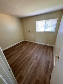 A room with a window and wooden flooring.