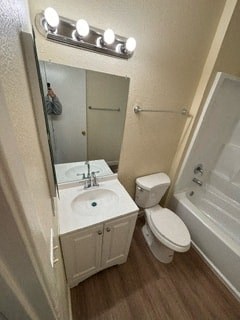A small bathroom with a toilet, sink, and mirror.