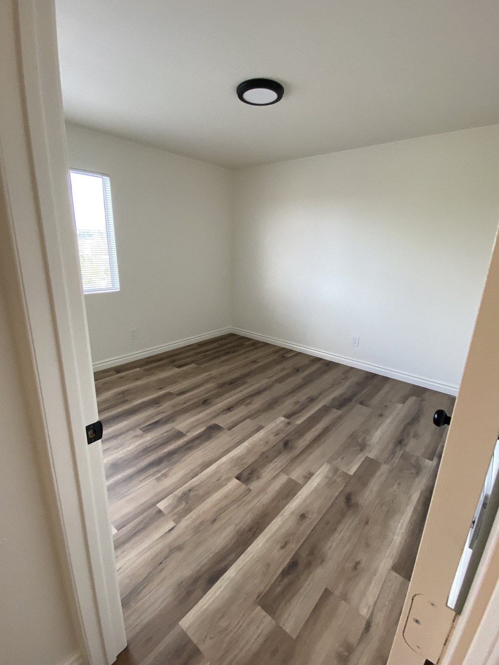 an empty room with wooden flooring in a house