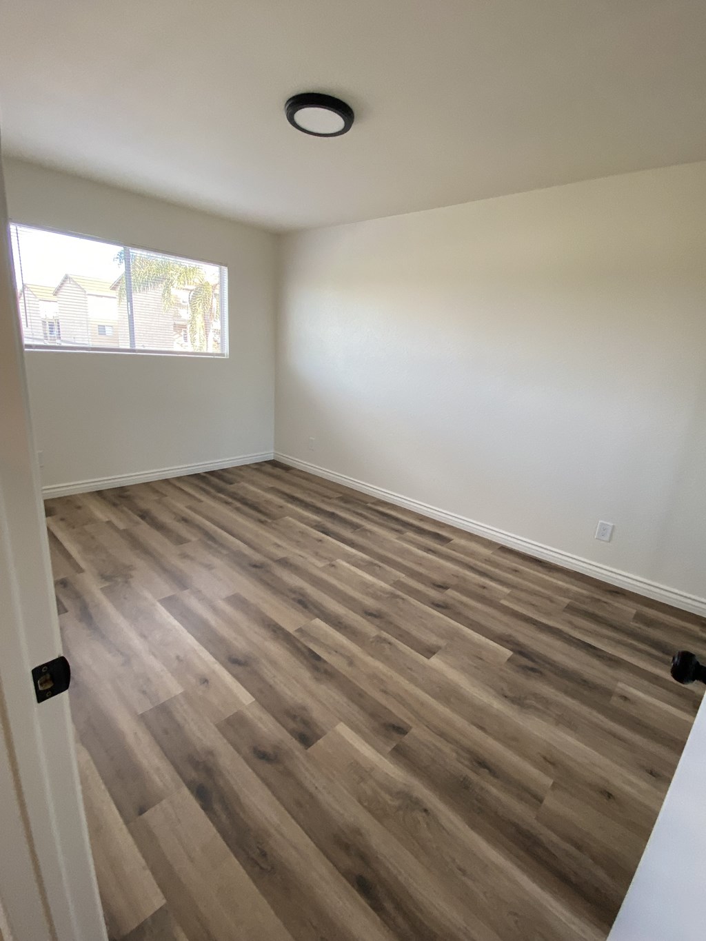 an empty room with wooden floors and a window