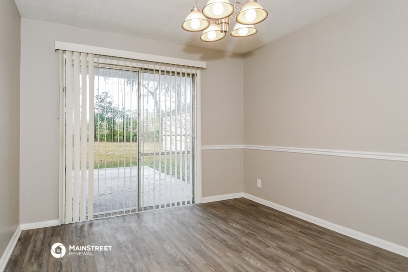 an empty living room with a sliding glass door to a yard